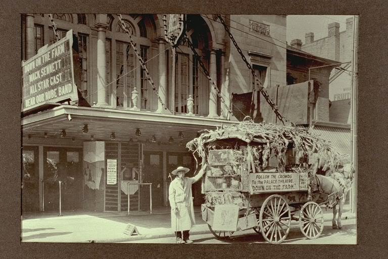 Photo of the Palace Theatre with a wagon in front advertising "Down on the Farm" - about 1920.