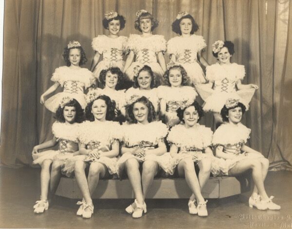 Photo of 13 girls in dance costumes.