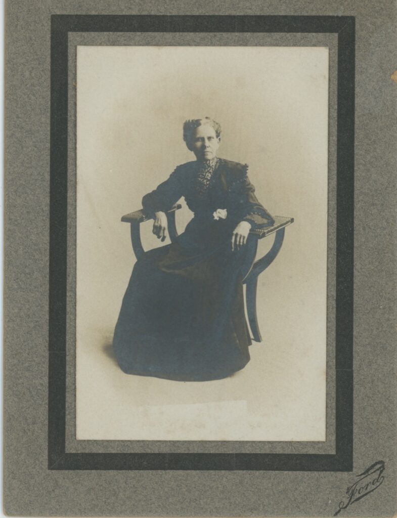 Cabinet card portrait of an elderly woman seated in an armchair, photographer Ford, circa 1887–1890.