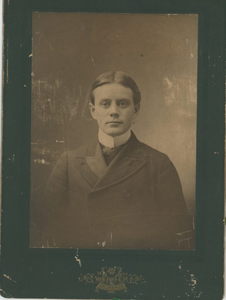 Cabinet card portrait of a young clean-shaven man in a dark double-breasted coat, photographer Webber, Brunswick, Maine, circa 1895–1900.