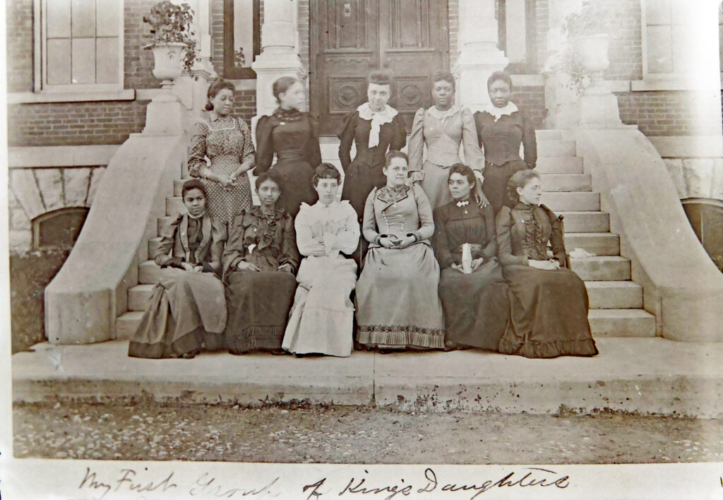Photo of 10 women on a wide set of stairs in front of a building