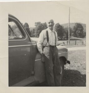 Photo of a man standing by a car