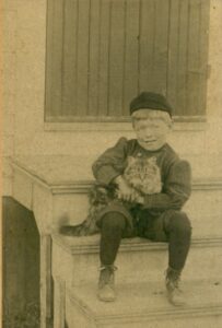 Photo of David Wright sitting on stairs holding a cat.