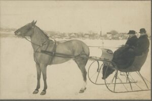 Photo of Ernest H. Dyer & an unknown man on a One-Horse Open Sleigh in winter.