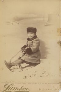Photo of John Chase Small, Jr. on a sled (age about 5).