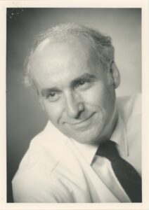 Photo of a man, wearing a tie.