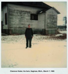 Photo of Edward standing in front of an old house in need of paint.