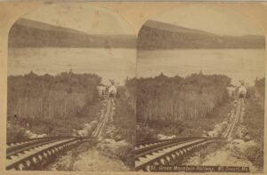 photo of a railroad track leading downhill towards the ocean.