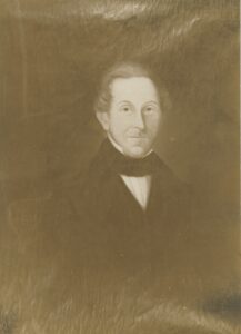 Sepia-toned photograph of an oil painting depicting an older gray-haired man in mid-19th century dress, wearing a dark coat and black bow tie.