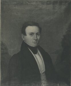 Black and white photograph of an oil painting depicting a dark-haired man in 1840s dress, wearing a dark coat with wide lapels and a white cravat.